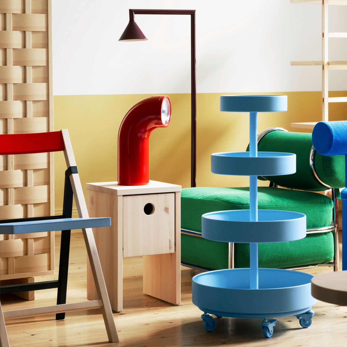 Kaasaegne puhkenurk rohelise IKEA PS 2026 tugitooli, tumepunase abilaua ja raamitud kunstiteosega.