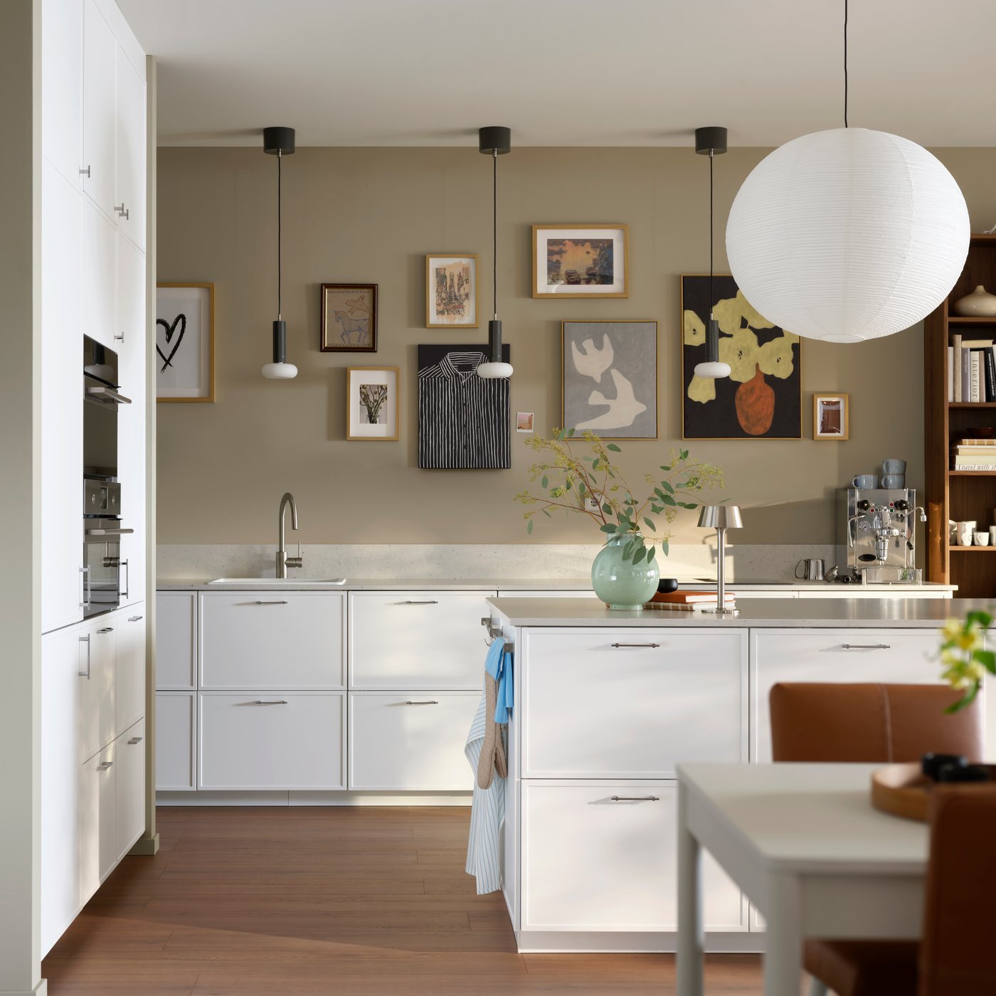 A kitchen with white METOD cabinets paired with ASPUDDEN matt white fronts featuring a kitchen island and modern decor.